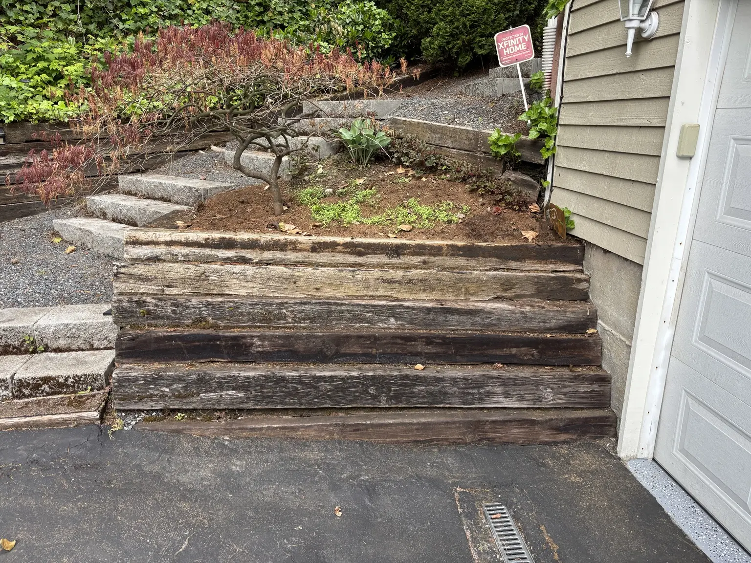 Before view of the deteriorated timber retaining wall beside the home entrance