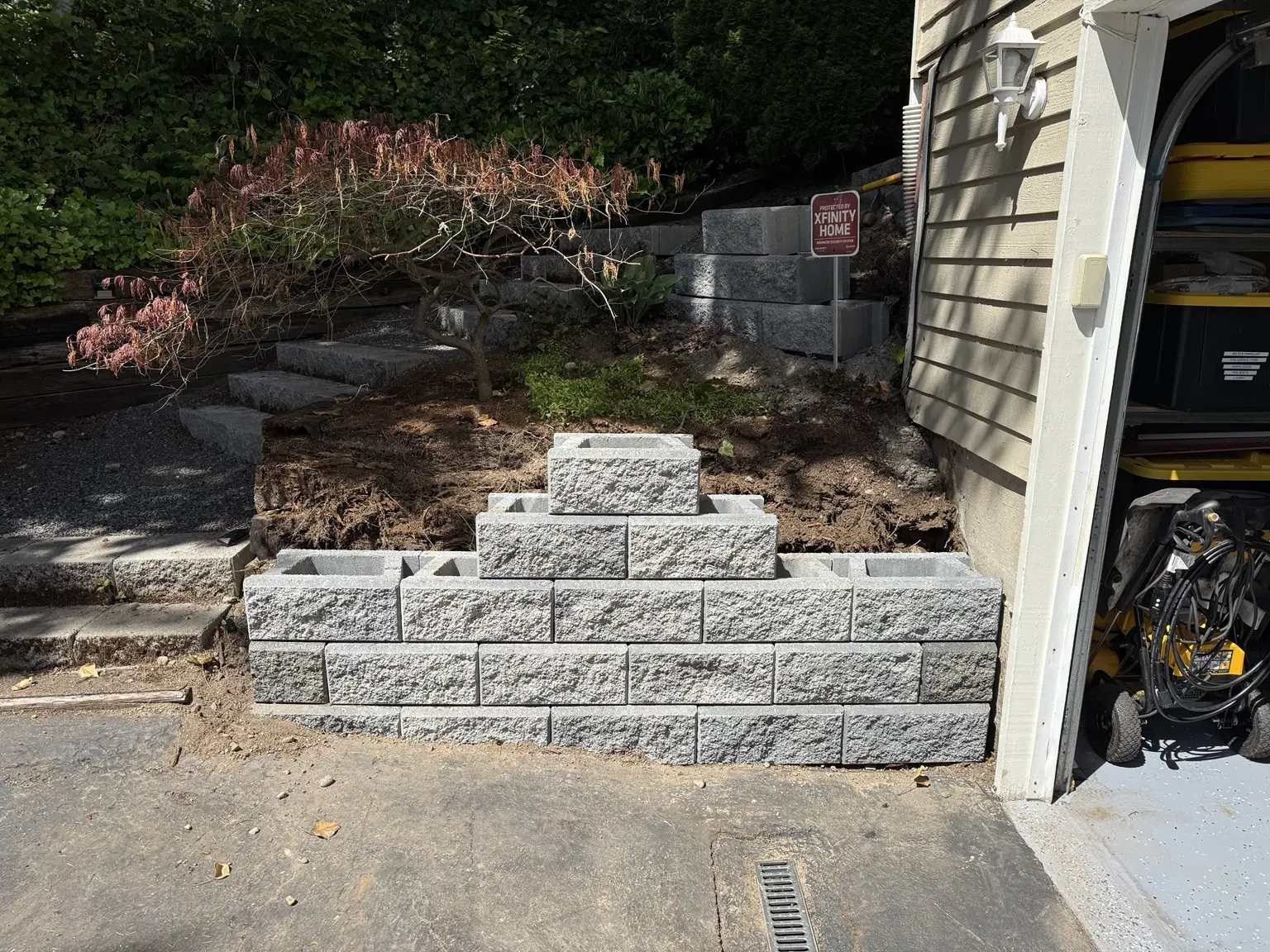 New segmental retaining wall being built beside the driveway entrance