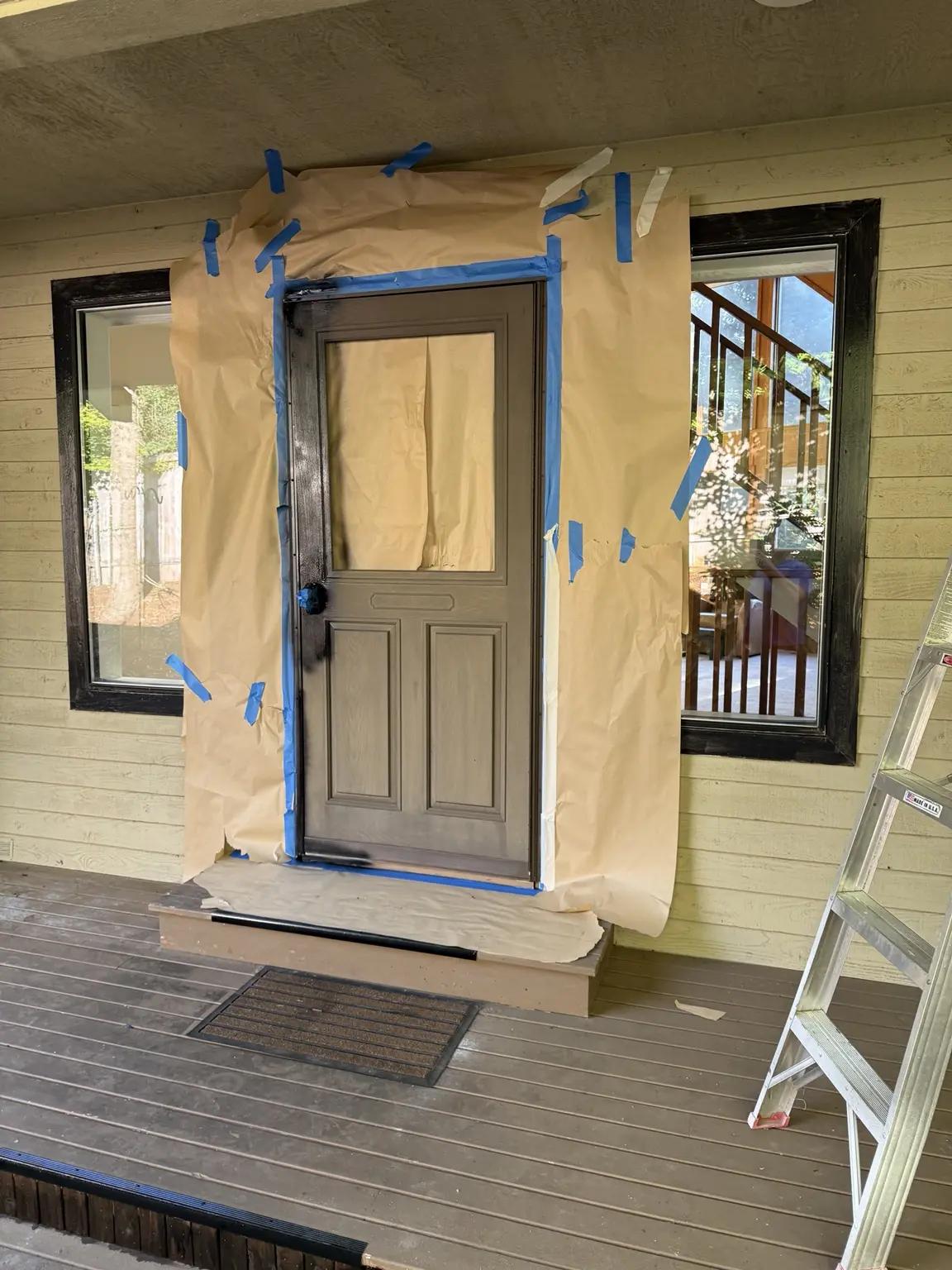 Front door and siding protected with masking paper and blue painter's tape