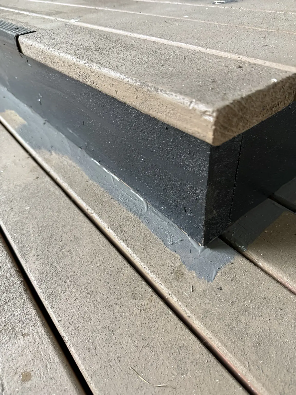 Close view of gray stair tread and black stair face after painting