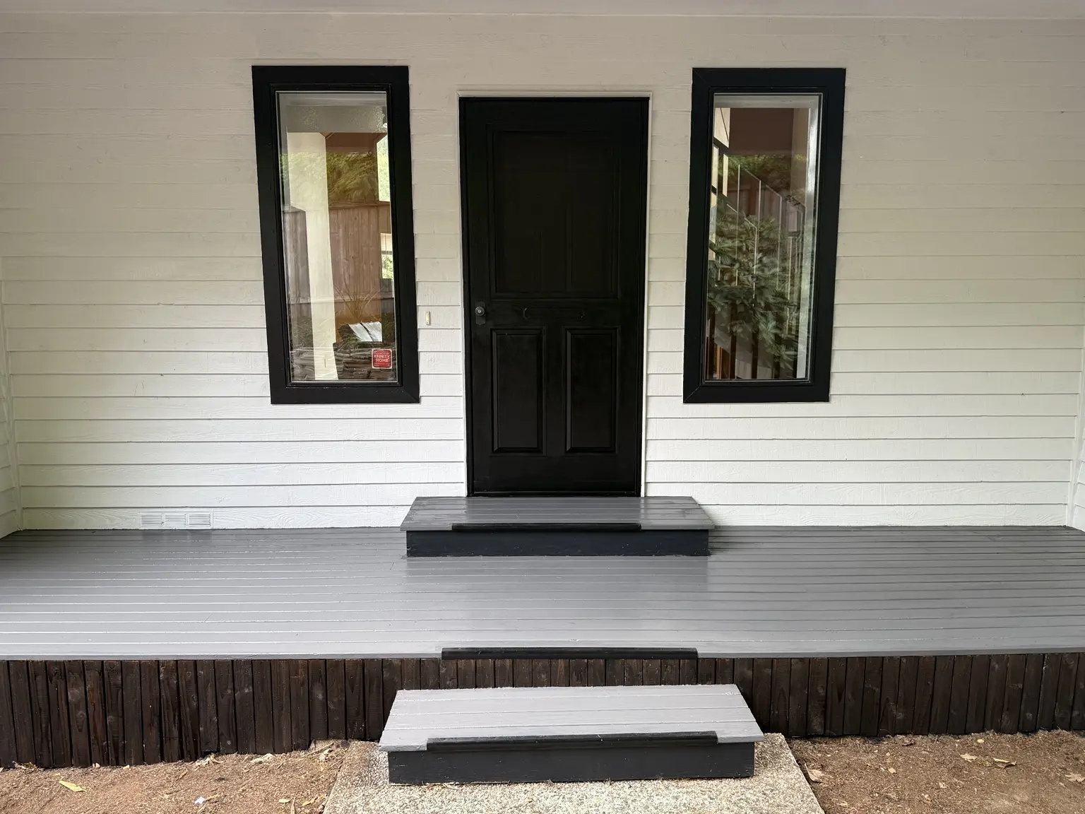Dark vertical boards beneath the finished porch