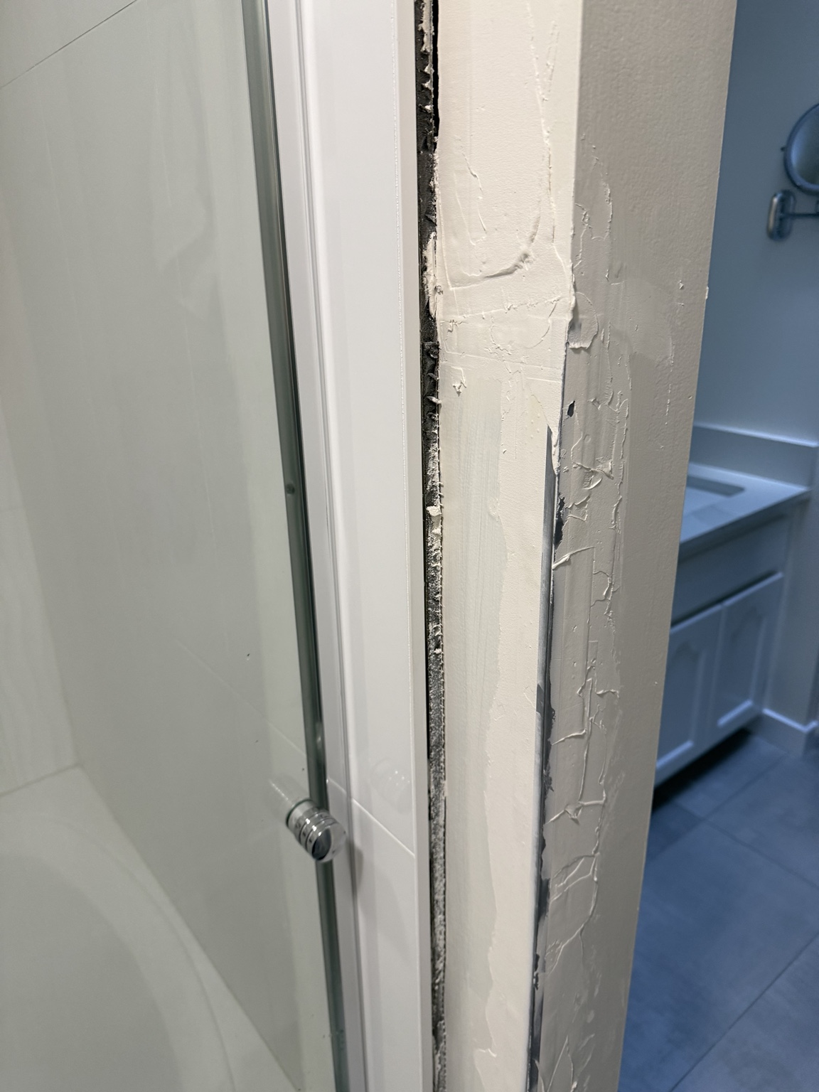 Close-up showing the depth and unfinished material inside the shower-side gap